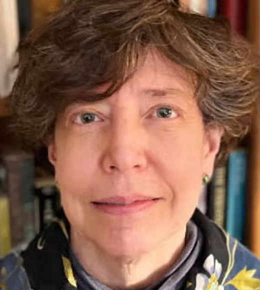 Woman wearing a floral scarf, standing in front of a bookcase