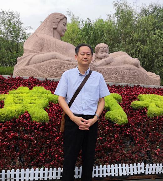 Man standing in front of garden statue