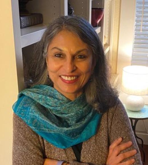 Woman in a teal scarf in front of a window