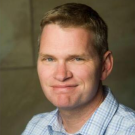 Blonde man in pale blue plaid shirt